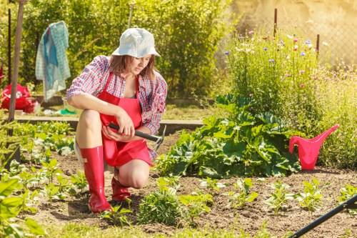 Gardener preparing soil with tools in Colebee garden