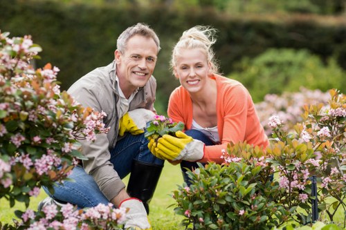 Professional gardener watering plants in Braeside